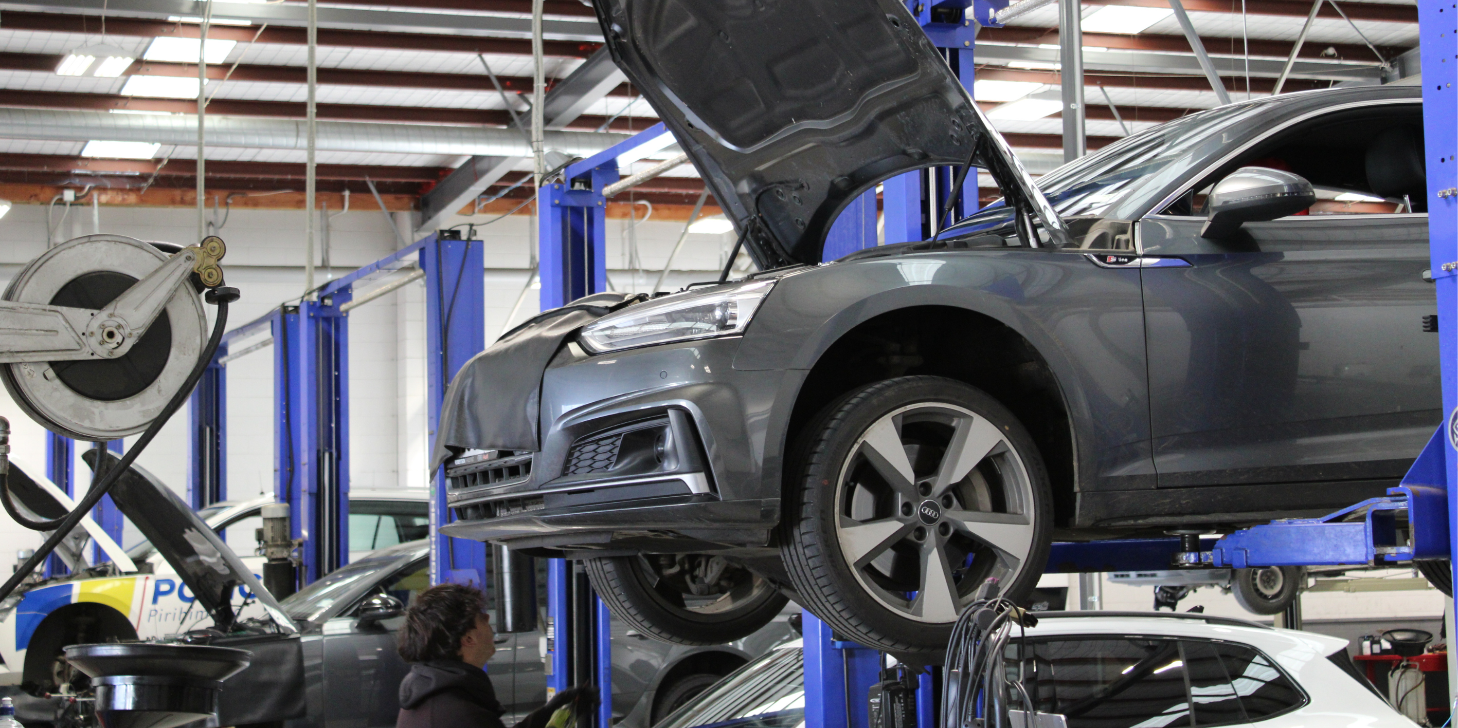 Vehicles in workshop bays being worked on robertson prestige service